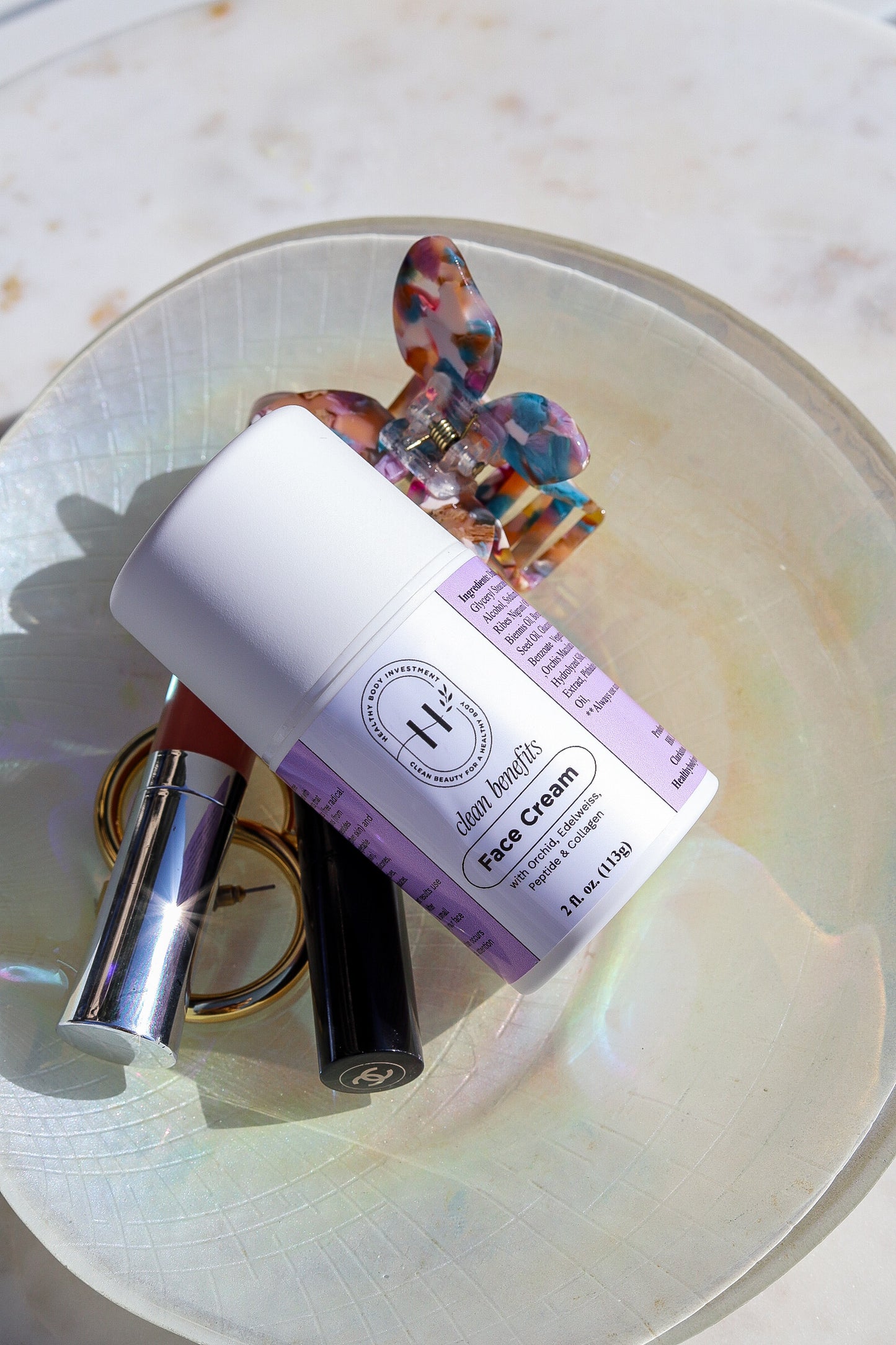 A bottle of face cream with a label indicating it is a product for skin care, placed on a surface with a colorful pattern.